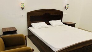 A neatly made bed with white linens, a wooden headboard, and two bedside tables with lamps.