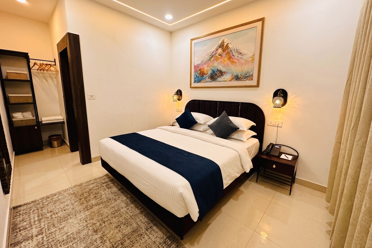 Une chambre à coucher avec un lit, des tables de chevet, une commode, un tableau et un ventilateur de plafond.