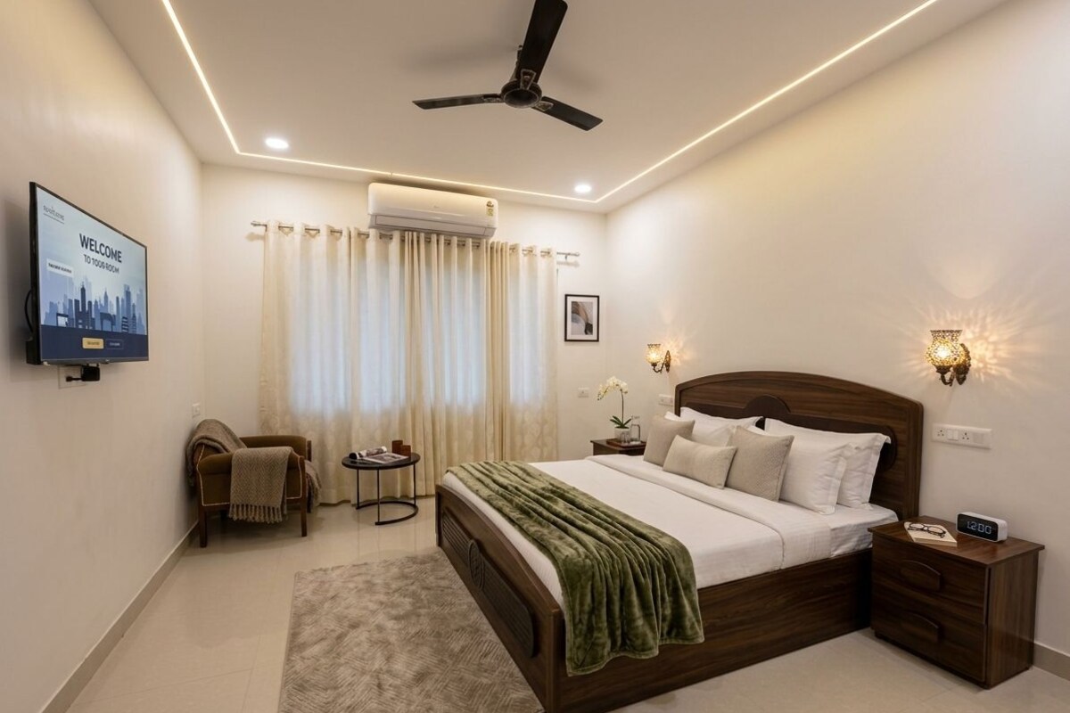 Une chambre moderne avec un lit, des tables de chevet, un téléviseur et un ventilateur de plafond.