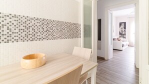 A modern bathroom with a wooden vanity, tiled backsplash, and a view into a living area. - GuestHost - Cosy APT Porta Venezia & Buenos Aires! (Milano)