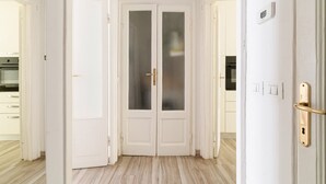 A hallway with a double door, a light switch, and a thermostat on the wall. - GuestHost - Cosy APT Porta Venezia & Buenos Aires! (Milano)