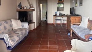 Un grand salon avec une cheminée, un canapé, un lit en bois et une table à manger.