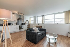 A modern living room with a grey sofa, a glass coffee table, and a lamp. - Marco Island 241 (Nottingham)