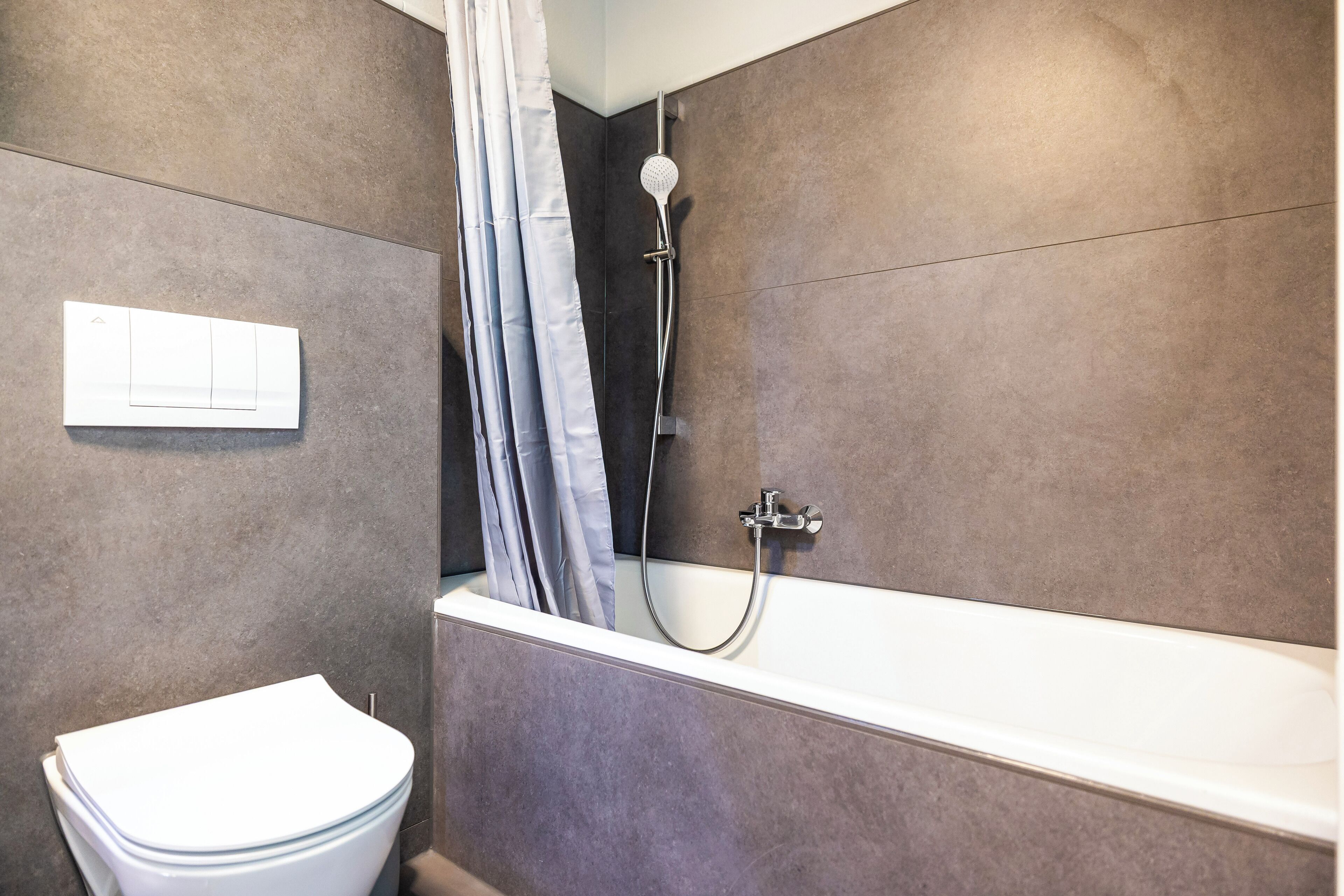 Un baño moderno con bañera, ducha e inodoro.