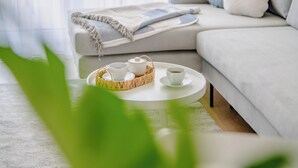 Un salon moderne avec un canapé, une table basse et un plateau contenant des tasses et une théière.