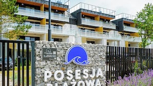 Une enseigne pour Posesja Plaza, avec un logo représentant une vague, indiquant que l’établissement est situé en bord de mer.