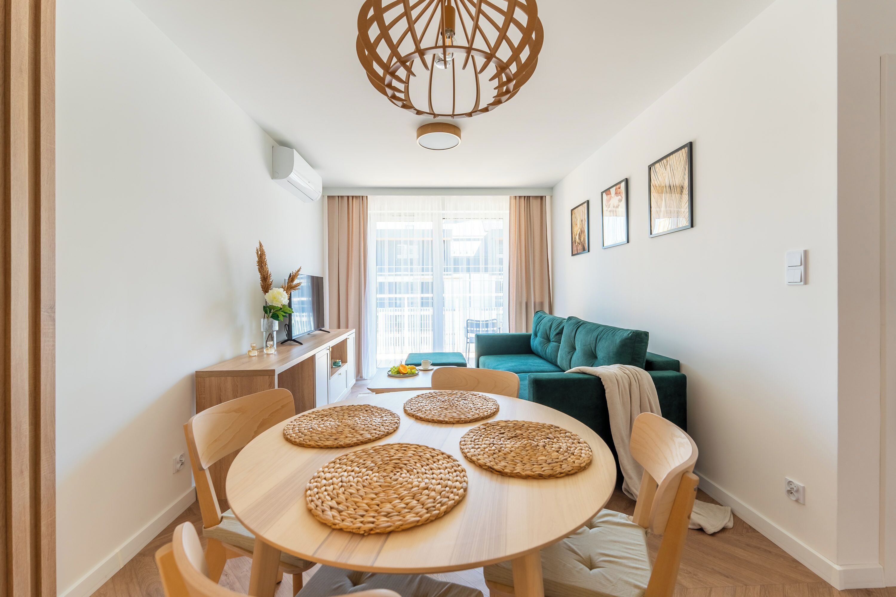A modern living room with a round dining table, a sofa, and a television.
