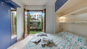 Un dormitorio con cama, baño y vista al exterior.