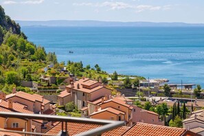 A coastal residential area with terracotta-roofed houses, a marina, and a clear view of the sea. - Ulivo sul golfo - Portopiccolo Apartments (Duino-Aurisina)