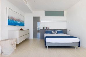 Um quarto moderno com cama, mesa de cabeceira e um quadro na parede.