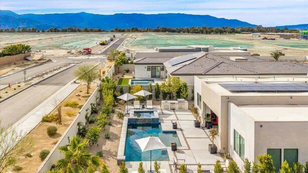 A modern hotel with a swimming pool, solar panels, and a view of mountains. - The Desert Oasis Casita (Palm Desert)