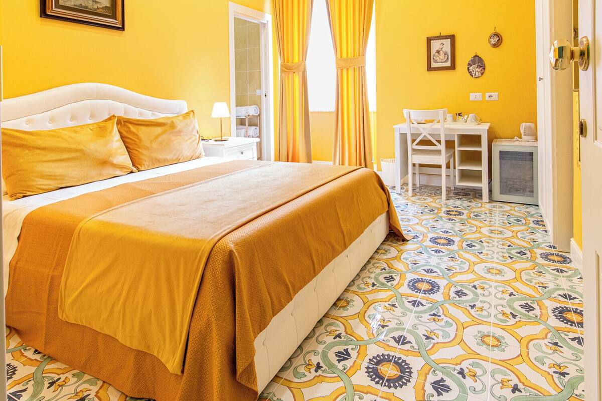 A hotel room with a bed, a desk, and a chair.