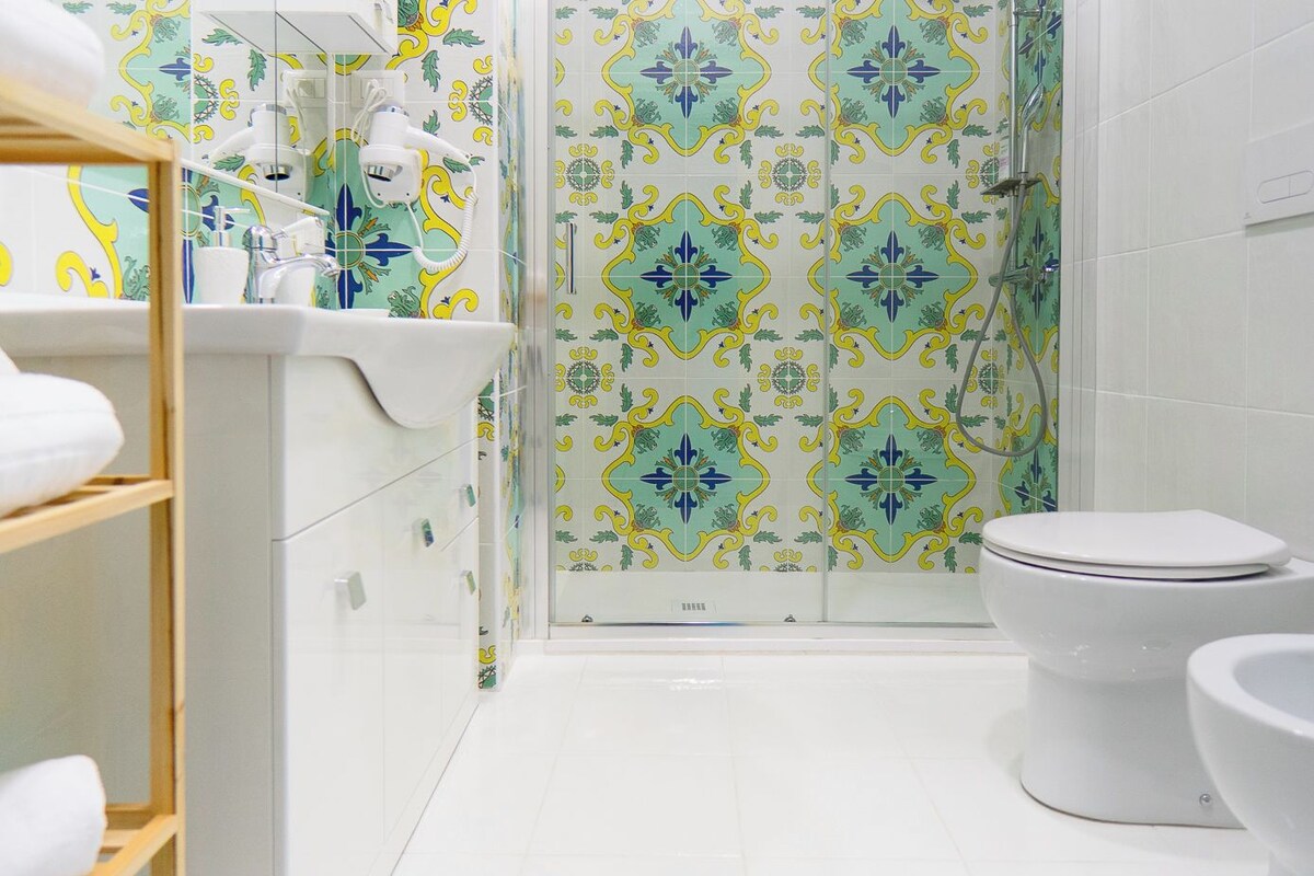 A bathroom with a shower, toilet, and sink.