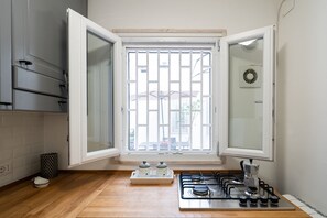 Een koelkast, een oven, een waterkoker, kookgerei, borden en bestek