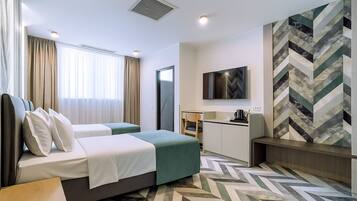 Ein Hotelzimmer mit Bett, Schreibtisch, Stuhl und Fernseher.