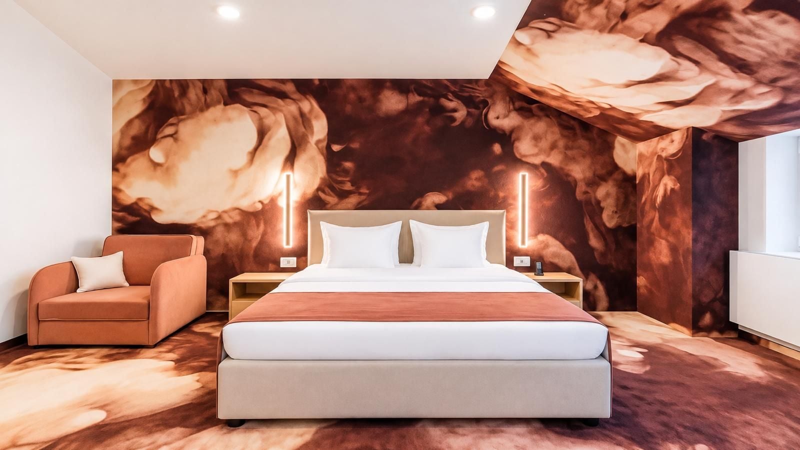 Une chambre moderne avec un grand lit, un canapé et une fresque murale.