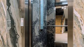 An elevator with a marble wall and a modern design.