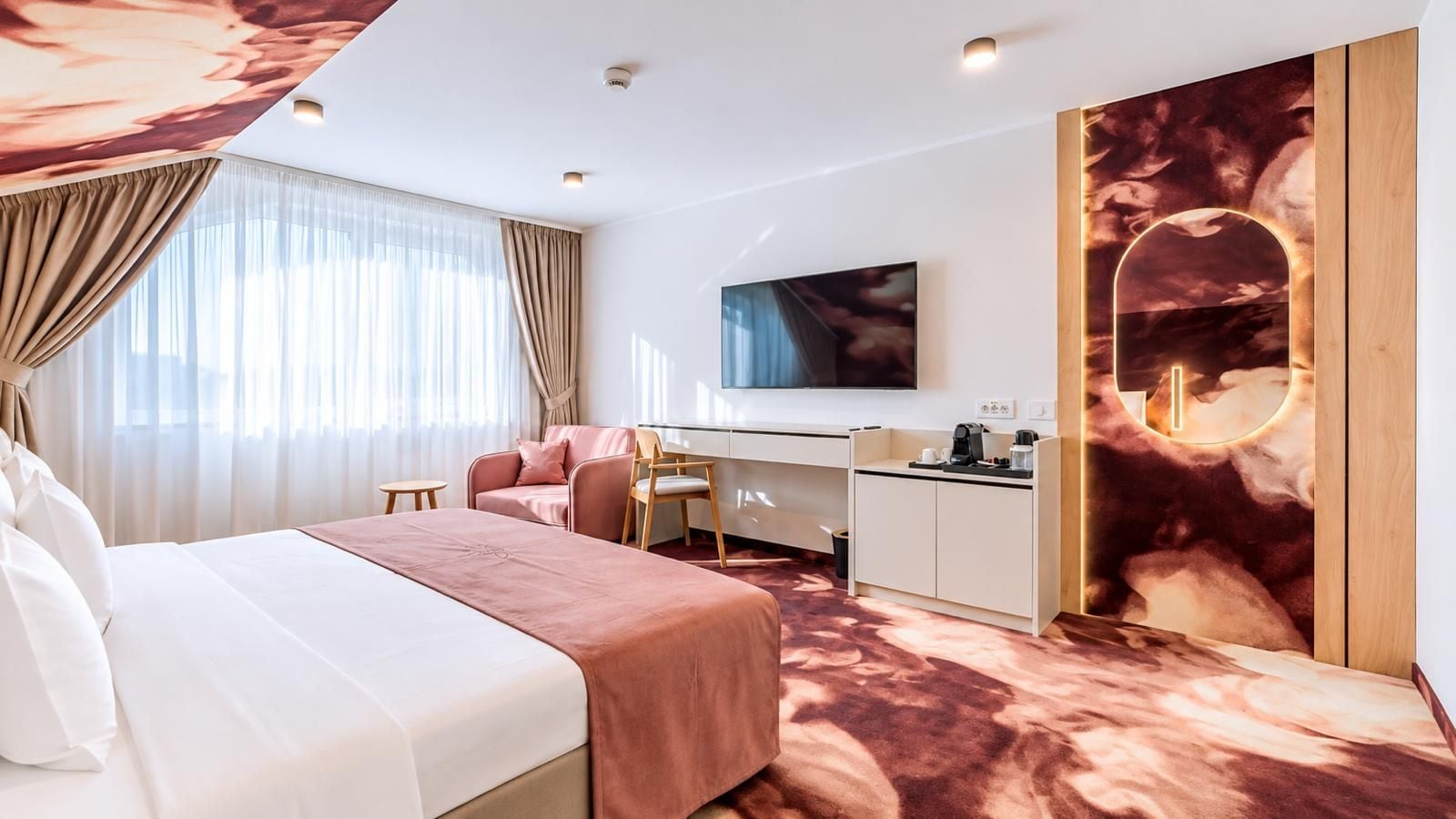 A hotel room with a bed, a desk, a chair, a TV, and a large window with curtains.
