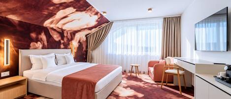 Una habitación de hotel con una cama grande, un escritorio, una silla, un televisor y un mural en el techo.