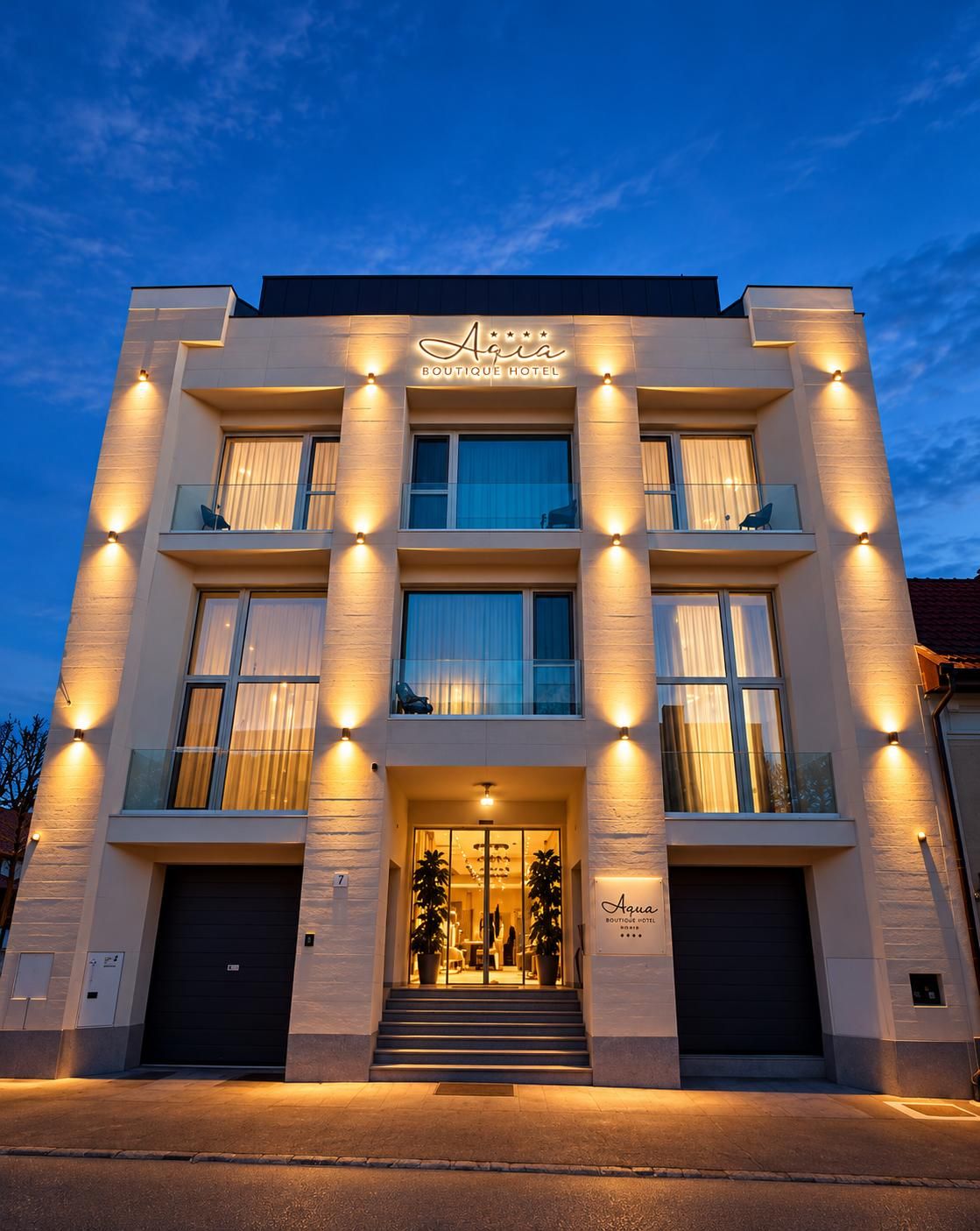 Un moderno hotel boutique con un cartel llamativo, varios balcones y una entrada bien iluminada.