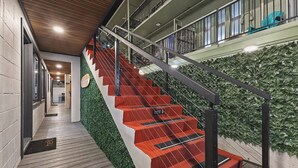 A staircase with red steps and a green wall, leading to a balcony with a view of the sky. - The Walk-Up Waikiki Beach  (Honolulu)
