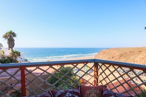 Un balcon avec vue sur la plage et l’océan.