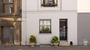 A building with a white facade, a black door, and a window with a flower box.