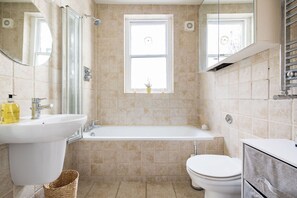 A bathroom with a sink, toilet, and bathtub. - Contemporary Apartment in Central Bloomsbury (London)