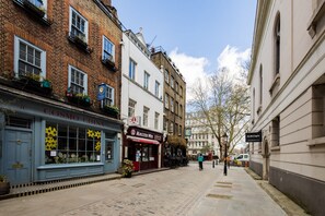 A narrow street lined with traditional buildings, including a shop with a sign reading "Cosmo China" and another with a "Master We" sign. - Contemporary Apartment in Central Bloomsbury (London)