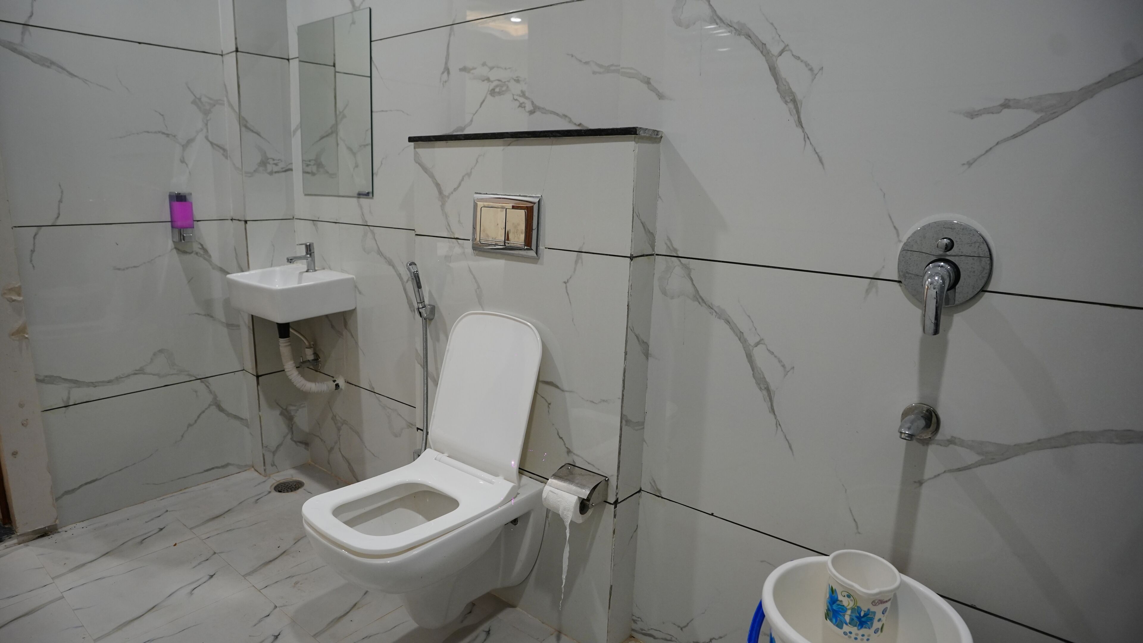 Une salle de bain avec des toilettes, un lavabo et une douche.