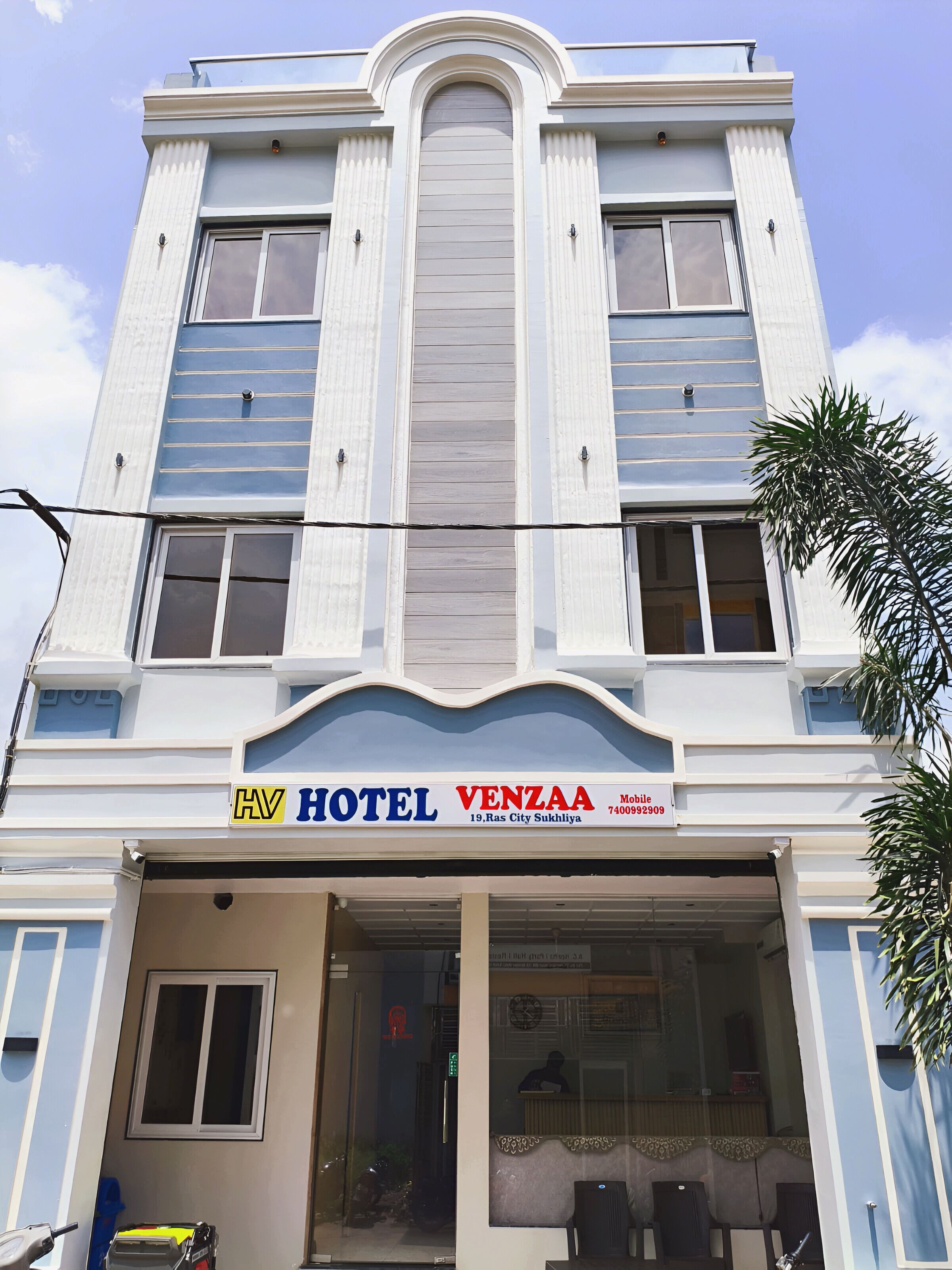 Un hotel con fachada moderna, un cartel llamativo y una entrada despejada.