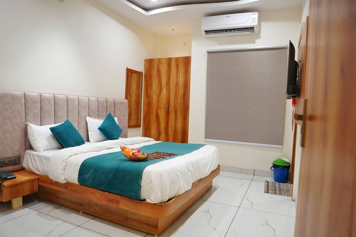 Un dormitorio con una cama de madera, una mesita de noche, un armario y una ventana con persianas.