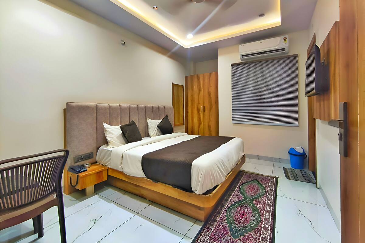 Un dormitorio moderno con una cama grande, cabecera de madera y ventilador de techo.