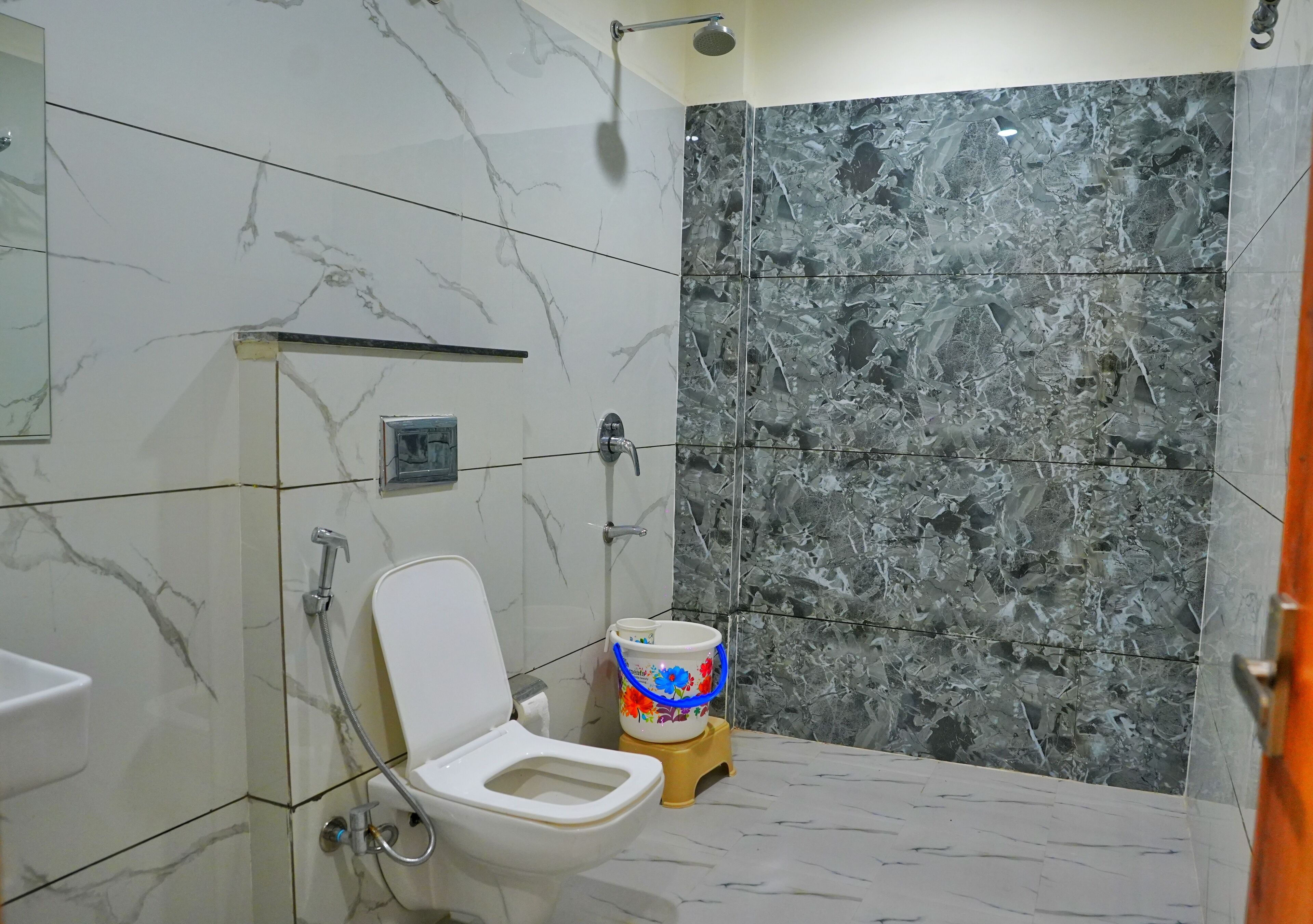Een badkamer met toilet, douche en wastafel.