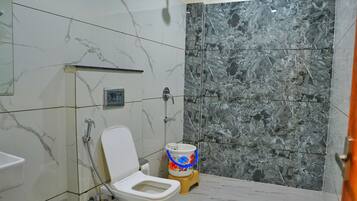 Een badkamer met toilet, douche en wastafel.