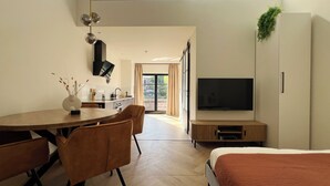 Ein moderner, offener Wohnbereich mit Essplatz, Küche und Schlafzimmer.
