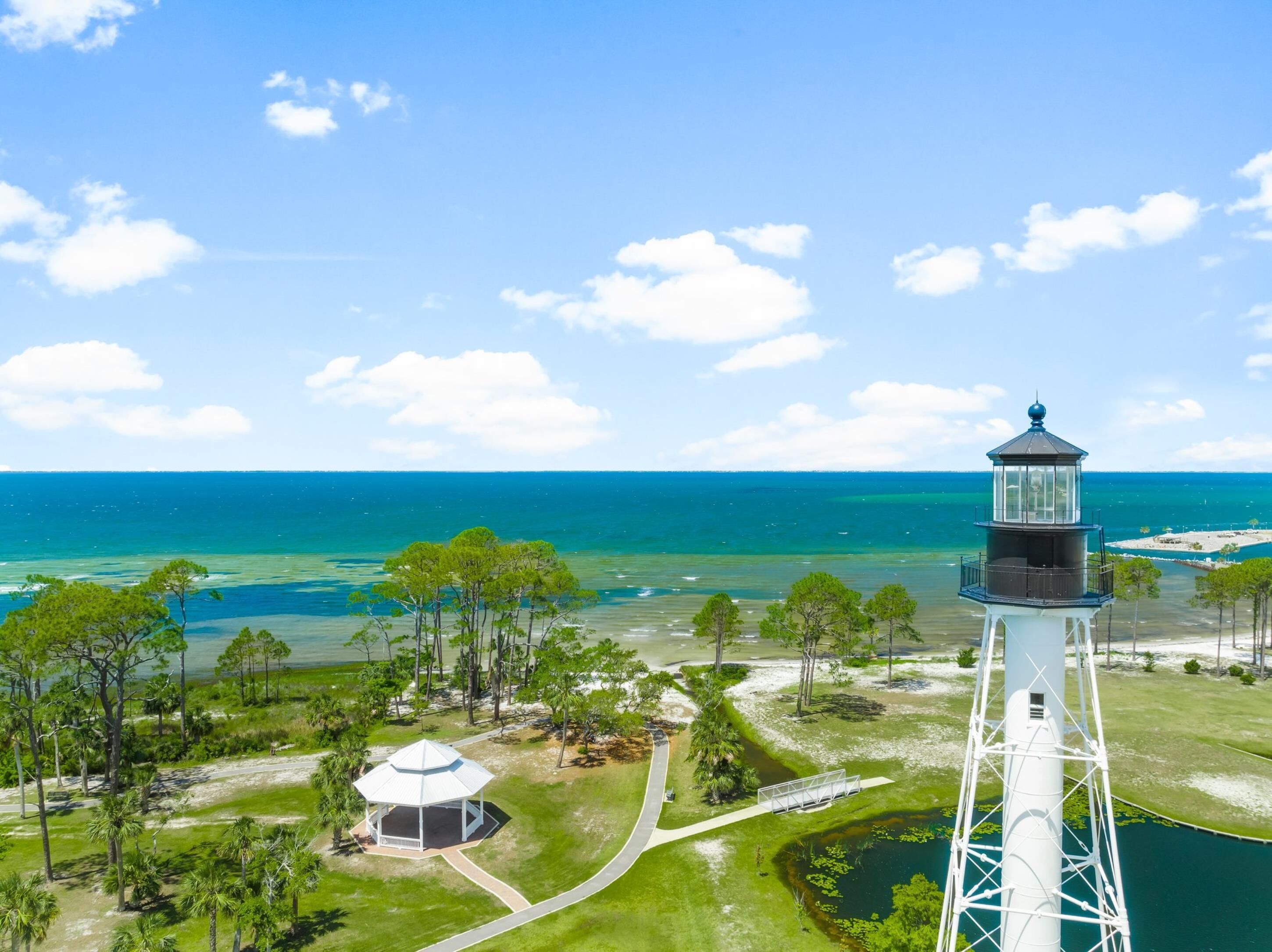 Un faro con vista despejada al océano y un pequeño pabellón en primer plano.