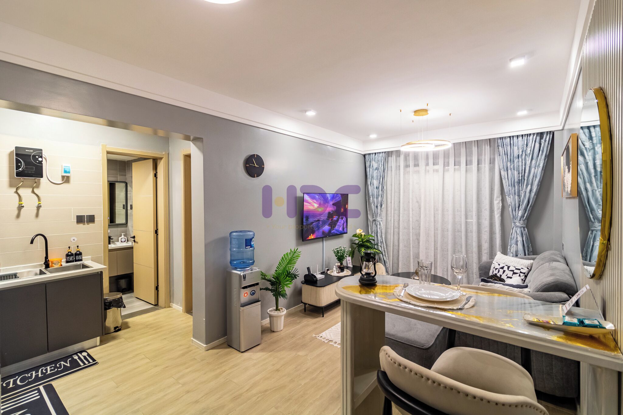 Una sala de estar moderna con comedor, cocina y dispensador de agua.