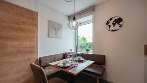 A dining area with a wooden table, brown chairs, and a world map on the wall.