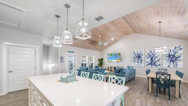 A spacious kitchen with a large island, wooden ceiling, and pendant lighting. - Spacious upscale home, community pool, private hot tub, close to the beach! (Port Aransas)