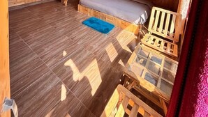 A wooden cabin interior with a bed, a small table, and a staircase. - Manali Mornings (Manali)