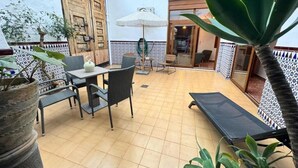 A courtyard with a table and chairs, a sun lounger, and potted plants. - HOLIDAY COTTAGE VILLALONGA RURAL (Vilallonga)