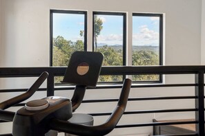 A chair with a sticker, positioned in front of a window with a view of trees and mountains. - Private Indoor Pool, Spacious Deck, Mountain Views (Sevierville)