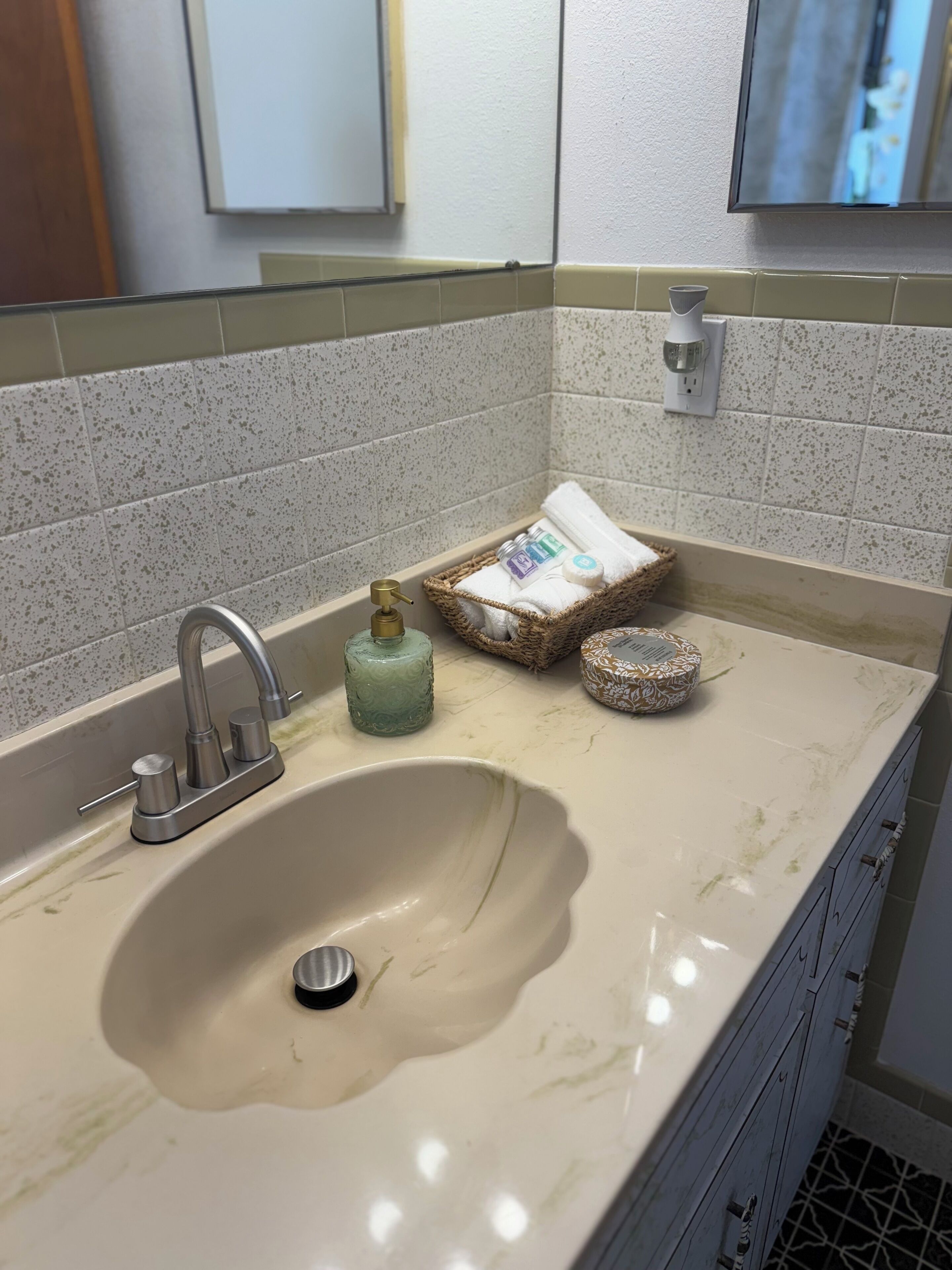 Une salle de bain avec un lavabo, un miroir et un porte-serviettes.