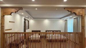 Un dormitorio con cabecera de madera, paredes de ladrillo blanco y un ventanal con cortinas.