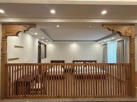Un dormitorio con cabecera de madera, paredes de ladrillo blanco y un ventanal con cortinas.