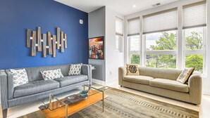 A living room with two sofas, a coffee table, and a large window with blinds. - 3 Mi to National Mall: Artsy DC Condo Near Metro! (Washington)