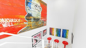 A staircase with a red and white wall mural, red bar stools, and framed artworks on the walls. - 3 Mi to National Mall: Artsy DC Condo Near Metro! (Washington)