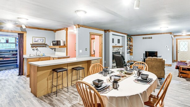 Une cuisine spacieuse dotée d’un îlot central, de chaises en bois et d’une table à manger pour quatre personnes.