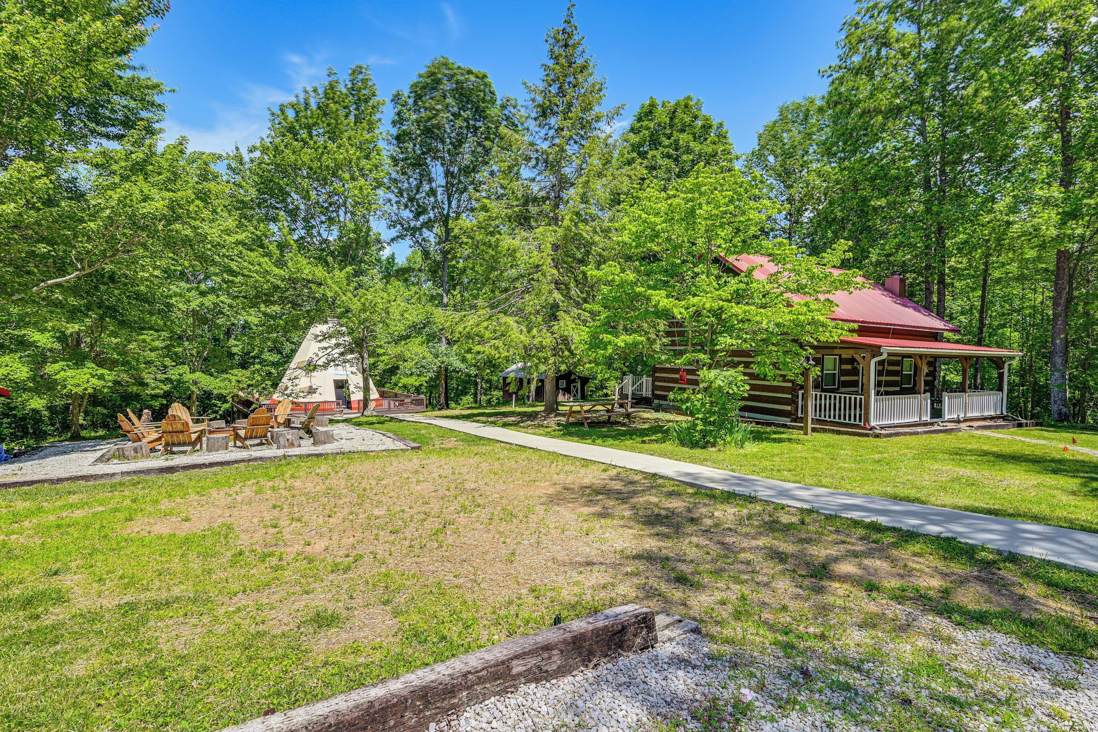 Un chalet rustique doté d’une véranda, entouré d’une forêt dense.